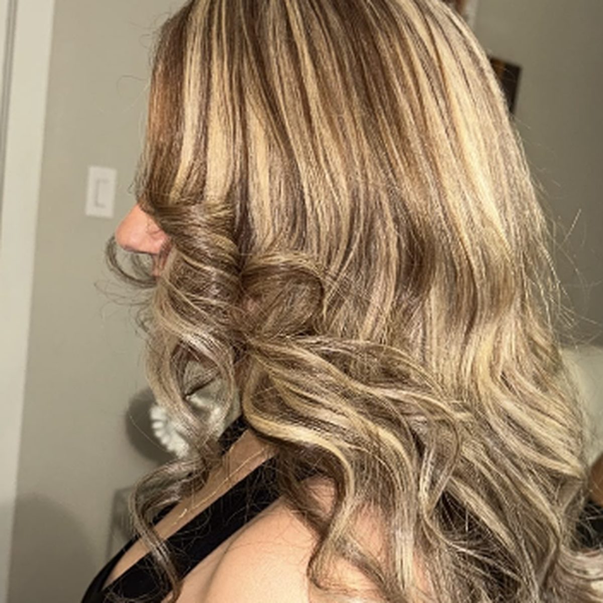 Side view of long curls with blonde highlights